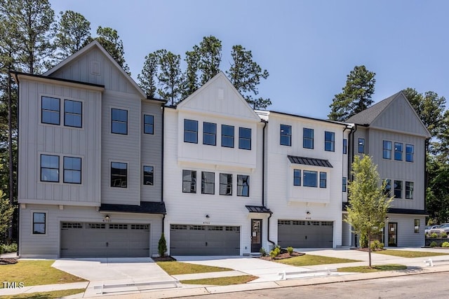 4703 Mint Leaf Ln, Raleigh, NC 27612 - townhome / multi-family property with board and batten siding, an attached garage, concrete driveway, and a standing seam roof