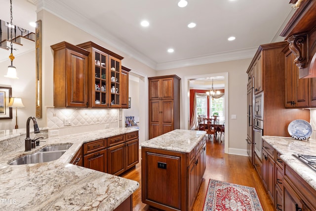 4164 English Garden Way, Raleigh, NC 27612 - kitchen with a chandelier, wood finished floors, light stone counters, tasteful backsplash, and glass insert cabinets