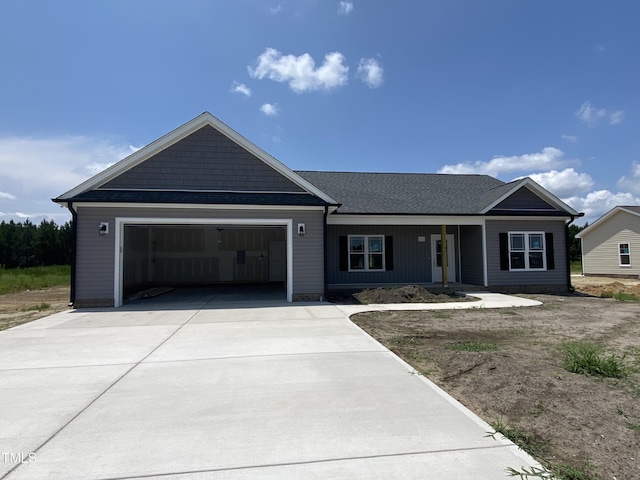 202 Rae Dr, Pikeville, NC 27863 - ranch-style house featuring an attached garage, concrete driveway, covered porch, and roof with shingles