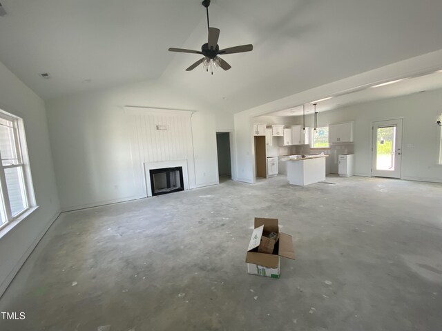 202 Rae Dr, Pikeville, NC 27863 - unfurnished living room featuring a fireplace, unfinished concrete flooring, ceiling fan, and high vaulted ceiling