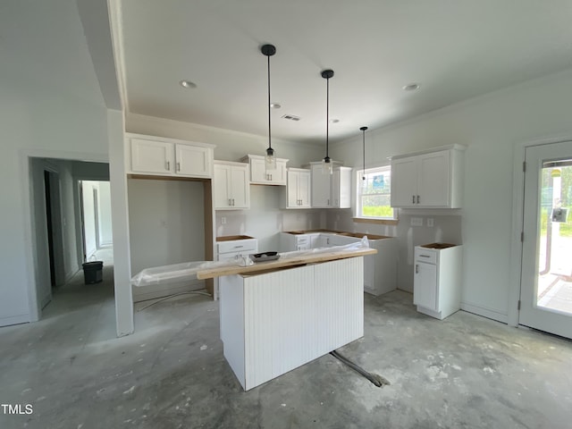 202 Rae Dr, Pikeville, NC 27863 - kitchen featuring a center island, unfinished concrete floors, white cabinetry, and crown molding