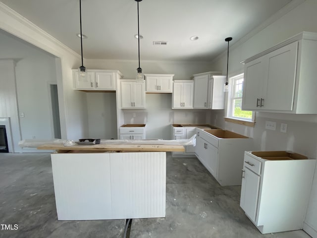 202 Rae Dr, Pikeville, NC 27863 - kitchen with concrete floors, a center island, white cabinets, and decorative light fixtures