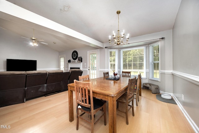 104 Fairfield Dr, Goldsboro, NC 27530 - dining room featuring light wood finished floors, a chandelier, a fireplace, healthy amount of natural light, and vaulted ceiling