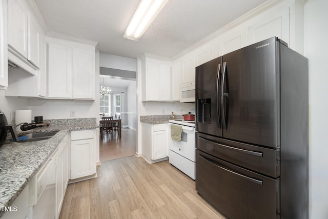 104 Fairfield Dr, Goldsboro, NC 27530 - kitchen featuring white appliances, light wood-type flooring, white cabinets, a chandelier, and a textured ceiling
