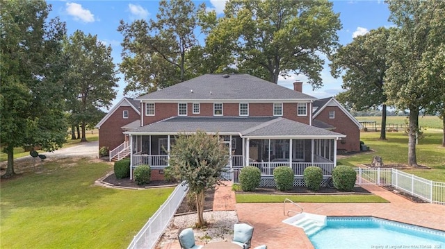 387 Three Bridge Rd, Dunn, NC 28334 - rear view of property featuring a sunroom, a fenced backyard, roof with shingles, a chimney, and a patio