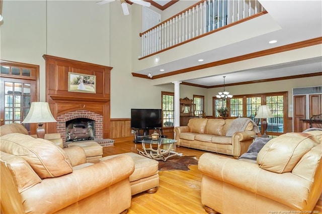 387 Three Bridge Rd, Dunn, NC 28334 - living area featuring light wood-style floors, crown molding, healthy amount of natural light, a chandelier, and a wainscoted wall