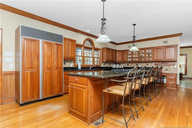 387 Three Bridge Rd, Dunn, NC 28334 - kitchen with paneled built in refrigerator, brown cabinets, light wood-style flooring, and crown molding