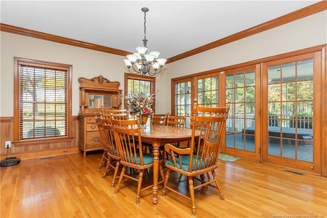 387 Three Bridge Rd, Dunn, NC 28334 - dining space with a chandelier, light wood-style flooring, ornamental molding, and a wainscoted wall