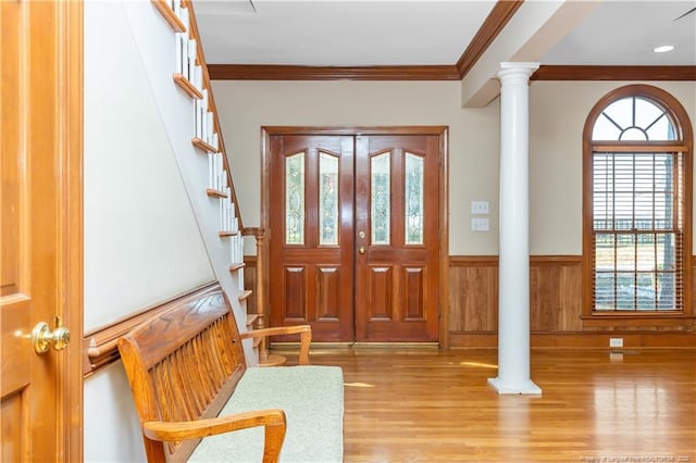 387 Three Bridge Rd, Dunn, NC 28334 - entrance foyer featuring wainscoting, crown molding, wood finished floors, stairway, and decorative columns