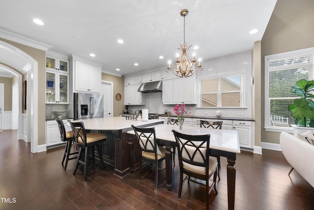 1089 Queensdale Dr, Cary, NC 27519 - kitchen with stainless steel fridge with ice dispenser, under cabinet range hood, a chandelier, a breakfast bar, and crown molding