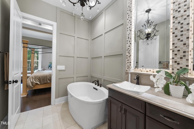 1089 Queensdale Dr, Cary, NC 27519 - ensuite bathroom featuring a chandelier, a freestanding tub, vanity, and tile patterned floors