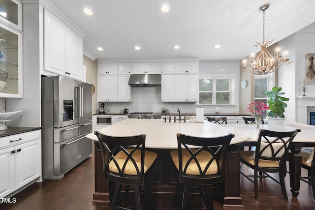 1089 Queensdale Dr, Cary, NC 27519 - kitchen featuring high end refrigerator, under cabinet range hood, dark wood-style floors, backsplash, and recessed lighting