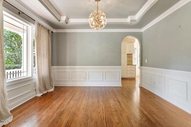 109 Gullane Ct, Apex, NC 27502 - empty room with arched walkways, a raised ceiling, light wood-style flooring, a chandelier, and crown molding