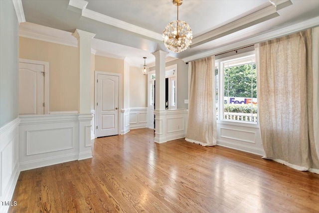 109 Gullane Ct, Apex, NC 27502 - empty room featuring a decorative wall, crown molding, decorative columns, wood finished floors, and wainscoting