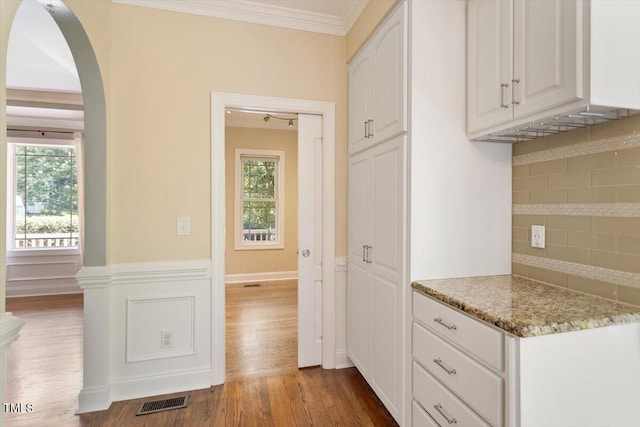 109 Gullane Ct, Apex, NC 27502 - kitchen with arched walkways, decorative backsplash, dark wood-style flooring, white cabinets, and healthy amount of natural light