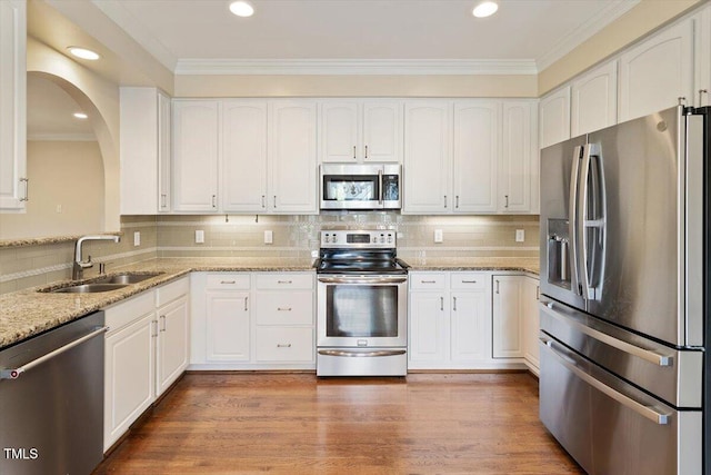 109 Gullane Ct, Apex, NC 27502 - kitchen with stainless steel appliances, light stone countertops, white cabinets, recessed lighting, and crown molding