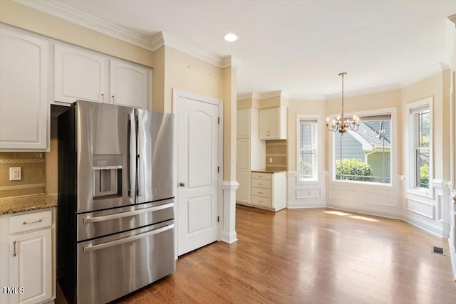 109 Gullane Ct, Apex, NC 27502 - kitchen featuring stainless steel fridge, a chandelier, light wood finished floors, dark stone countertops, and backsplash