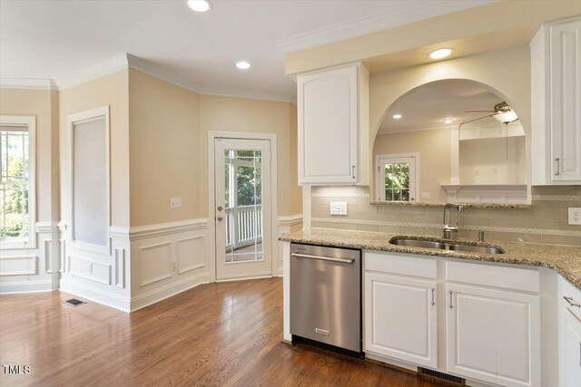 109 Gullane Ct, Apex, NC 27502 - kitchen with stainless steel dishwasher, ceiling fan, white cabinets, light stone counters, and wainscoting