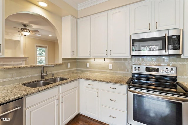 109 Gullane Ct, Apex, NC 27502 - kitchen with stainless steel appliances, crown molding, ceiling fan, white cabinets, and light stone counters