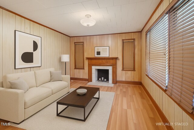 3702 Danube Ln, Durham, NC 27704 - living room featuring ornamental molding, light wood-type flooring, wooden walls, and a tile fireplace