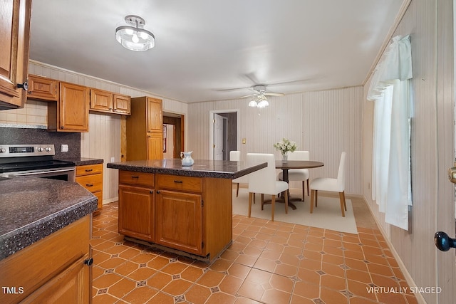 3702 Danube Ln, Durham, NC 27704 - kitchen with stainless steel electric stove, a ceiling fan, decorative backsplash, brown cabinets, and ornamental molding
