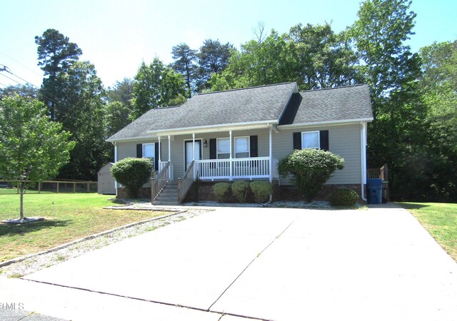 409 James Toney Dr, Elon, NC 27244 - view of front of house featuring a porch, a front lawn, a storage shed, and a shingled roof