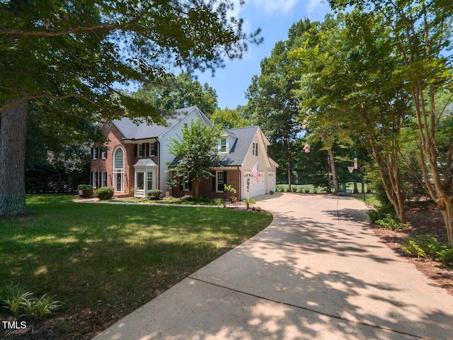 5032 Salem Ridge Rd, Holly Springs, NC 27540 - colonial-style house with concrete driveway, brick siding, a front yard, and a garage