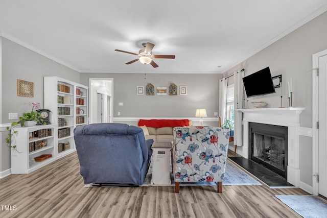 115 Creech Place Dr, Benson, NC 27504 - living area with ceiling fan, wood finished floors, a fireplace with raised hearth, and crown molding