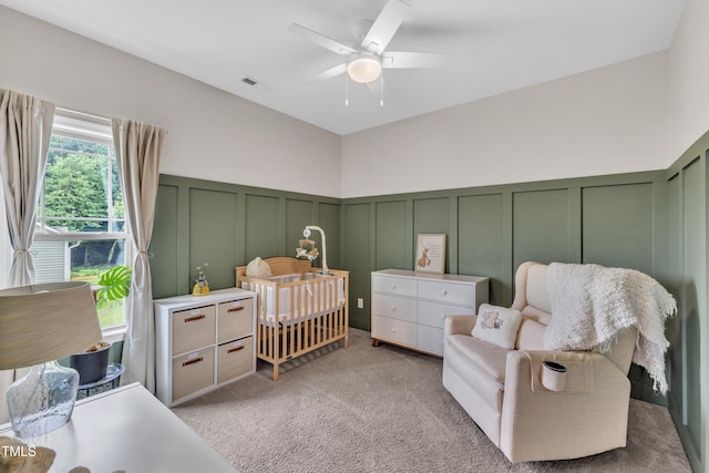 115 Creech Place Dr, Benson, NC 27504 - bedroom with a decorative wall, light carpet, a nursery area, ceiling fan, and wainscoting