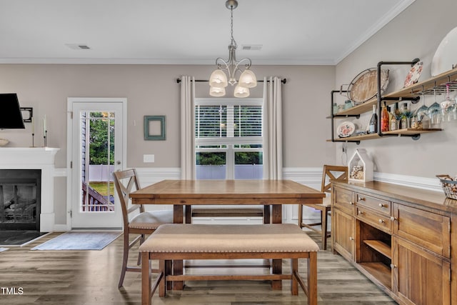 115 Creech Place Dr, Benson, NC 27504 - dining room featuring a chandelier, ornamental molding, light wood finished floors, a glass covered fireplace, and a wainscoted wall
