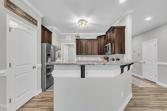 115 Creech Place Dr, Benson, NC 27504 - kitchen with stainless steel appliances, dark brown cabinetry, light wood-style flooring, recessed lighting, and ornamental molding