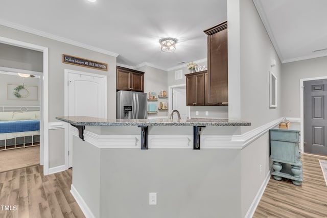 115 Creech Place Dr, Benson, NC 27504 - kitchen featuring stainless steel fridge with ice dispenser, dark brown cabinetry, light wood-style flooring, a breakfast bar, and light stone counters