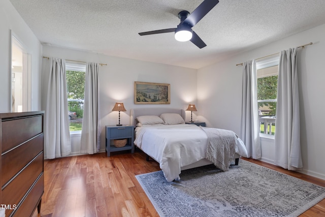 107 Leighton Pl, Knightdale, NC 27545 - bedroom featuring a textured ceiling, multiple windows, light wood finished floors, and ceiling fan