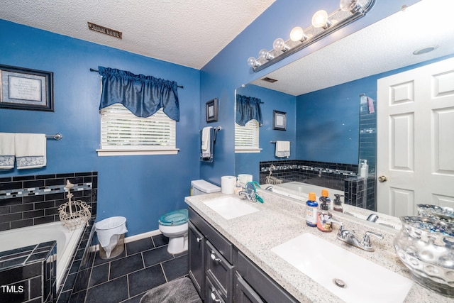 501 Dandelion Ct, Raleigh, NC 27610 - bathroom featuring a bath, tile patterned flooring, a textured ceiling, and double vanity