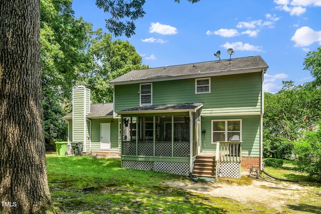 501 Dandelion Ct, Raleigh, NC 27610 - back of house featuring a chimney, a sunroom, a yard, and roof with shingles