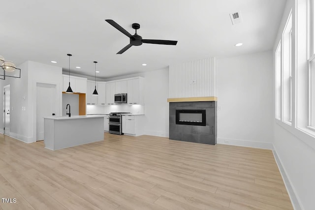 140 E End Ave, Durham, NC 27703 - kitchen with stainless steel appliances, ceiling fan, light wood-style flooring, open floor plan, and light countertops