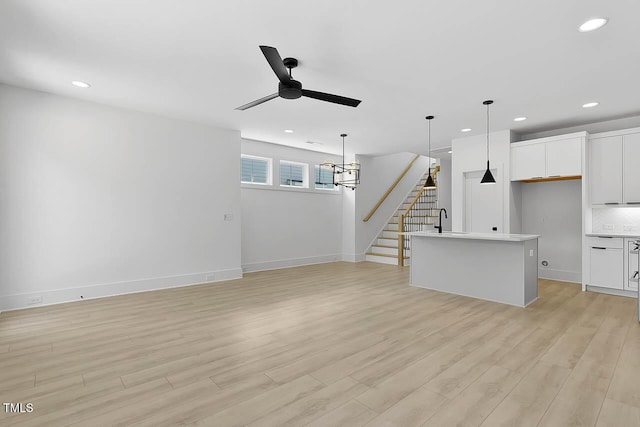 140 E End Ave, Durham, NC 27703 - unfurnished living room featuring a ceiling fan, recessed lighting, light wood finished floors, and stairway