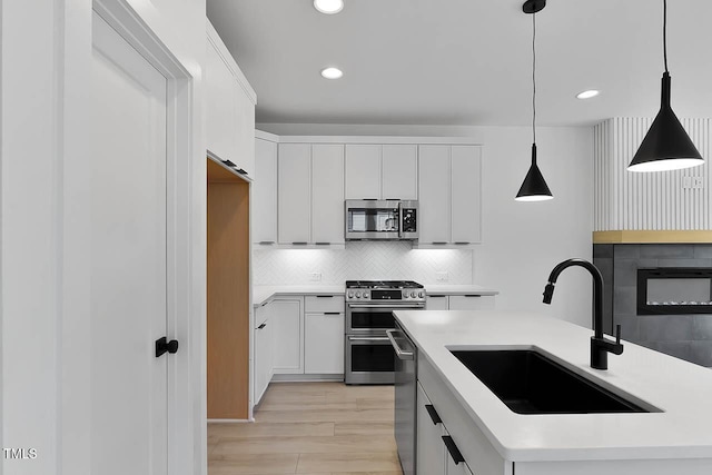 140 E End Ave, Durham, NC 27703 - kitchen with appliances with stainless steel finishes, recessed lighting, light countertops, hanging light fixtures, and decorative backsplash