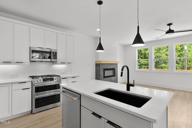 140 E End Ave, Durham, NC 27703 - kitchen with appliances with stainless steel finishes, decorative backsplash, light countertops, light wood finished floors, and recessed lighting