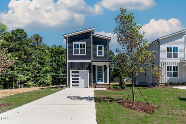140 E End Ave, Durham, NC 27703 - contemporary house with board and batten siding, a front yard, concrete driveway, and a garage