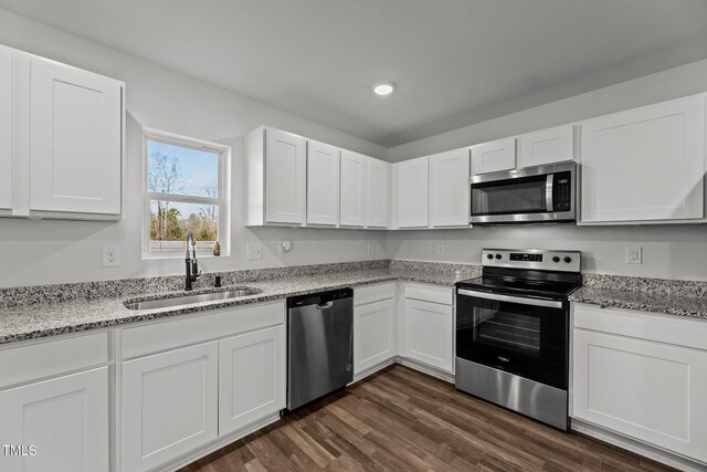 9059 Shallow Creek Trl, Bailey, NC 27807 - kitchen with appliances with stainless steel finishes, white cabinetry, dark wood-style floors, recessed lighting, and light stone countertops