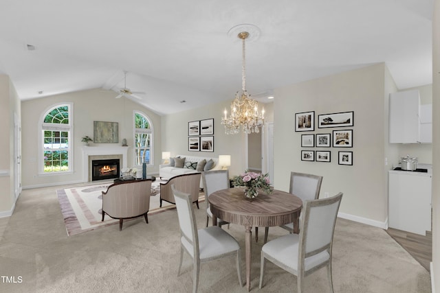 4710 Ludwell Branch Ct, Raleigh, NC 27612 - dining area featuring a ceiling fan, light carpet, a warm lit fireplace, lofted ceiling, and a chandelier