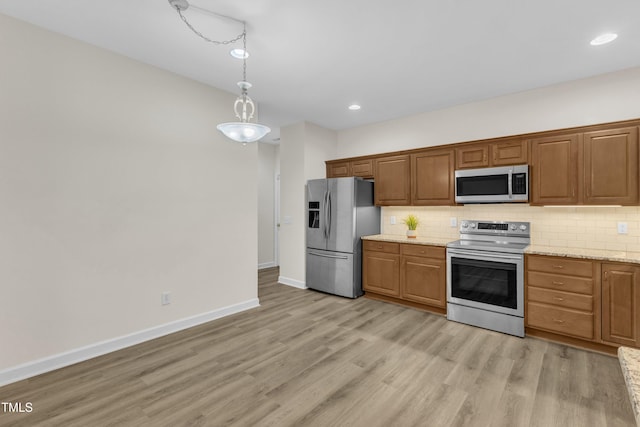 4710 Ludwell Branch Ct, Raleigh, NC 27612 - kitchen featuring appliances with stainless steel finishes, tasteful backsplash, light wood finished floors, hanging light fixtures, and recessed lighting