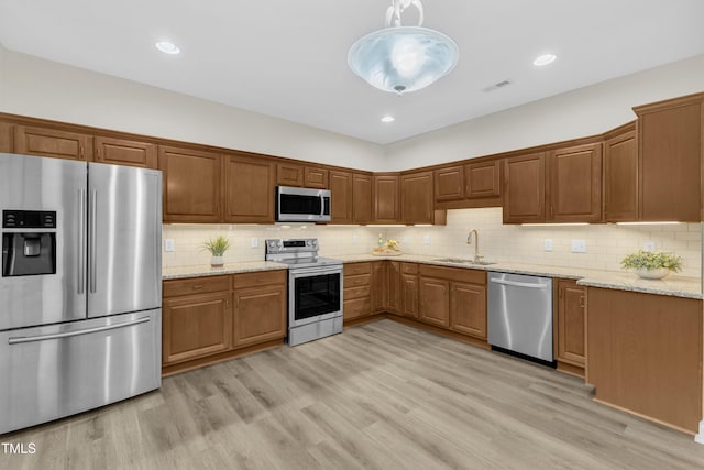 4710 Ludwell Branch Ct, Raleigh, NC 27612 - kitchen featuring stainless steel appliances, tasteful backsplash, light stone countertops, light wood-style floors, and recessed lighting