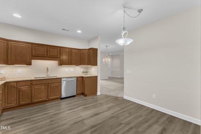 4710 Ludwell Branch Ct, Raleigh, NC 27612 - kitchen with stainless steel dishwasher, tasteful backsplash, light wood-style floors, hanging light fixtures, and a chandelier