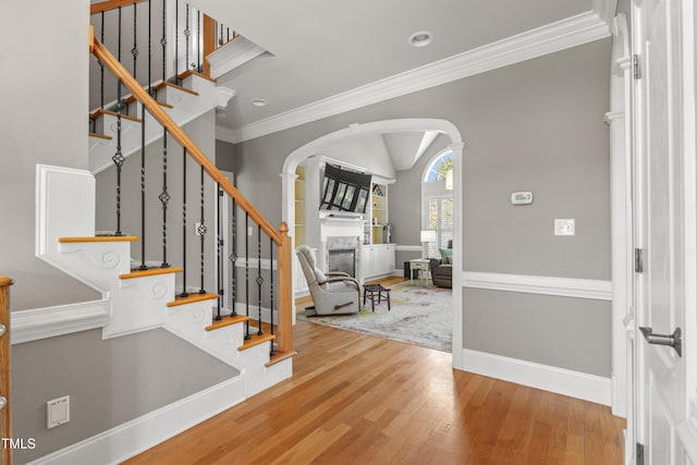 2512 Stewart St, Fuquay Varina, NC 27526 - foyer featuring arched walkways, a fireplace, wood finished floors, ornamental molding, and stairs
