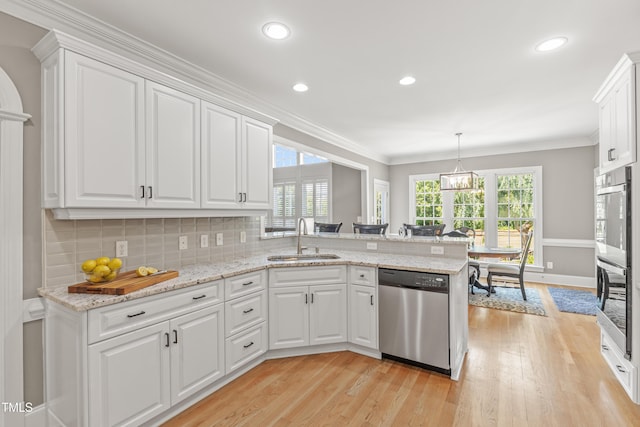 2512 Stewart St, Fuquay Varina, NC 27526 - kitchen featuring appliances with stainless steel finishes, light wood-style flooring, white cabinetry, a peninsula, and healthy amount of natural light
