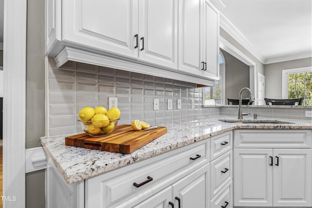 2512 Stewart St, Fuquay Varina, NC 27526 - kitchen with white cabinetry, backsplash, crown molding, and light stone countertops