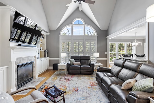 2512 Stewart St, Fuquay Varina, NC 27526 - living room with ceiling fan, light wood-type flooring, a tiled fireplace, a chandelier, and high vaulted ceiling