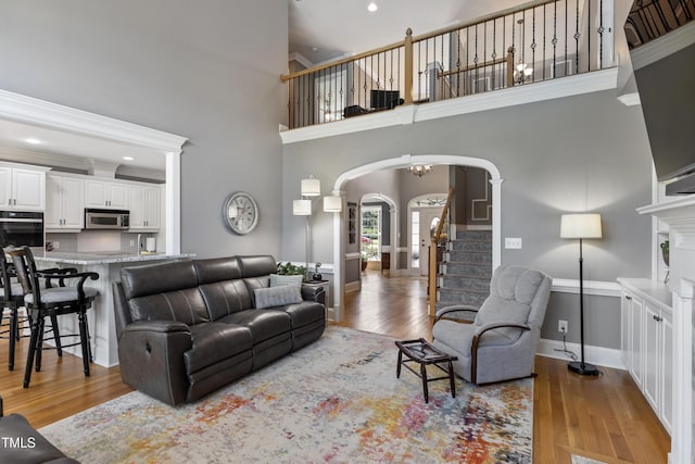 2512 Stewart St, Fuquay Varina, NC 27526 - living room with arched walkways, wood finished floors, a towering ceiling, stairs, and recessed lighting